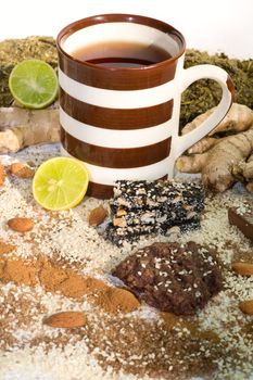 cup of tea with ingredients for tea, and cookies  on a white background