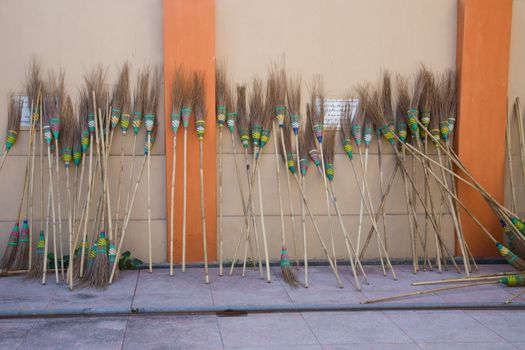 Old wooden brooms ready fly or sweep near wall in myanmar 