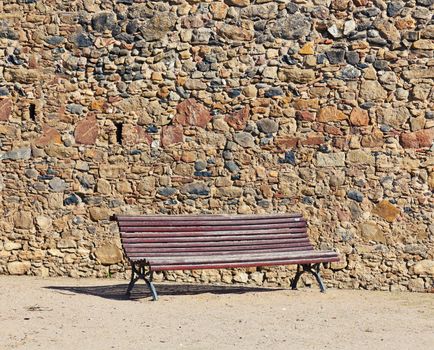 vintage bench near stone wall