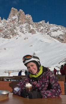The girl at the table mountain cafe. Ski resort of Selva di Val Gardena, Italy