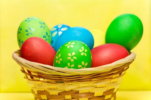 Colored  easter eggs  laying in wood basket