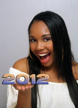 A close-up of a lovely young Haitian girl with a captivating smile and holding "2012" in her extended hand.