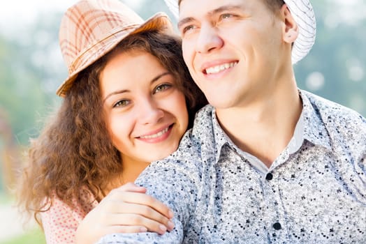 romantic couple lying on the grass in the summer park, spending time with loved ones
