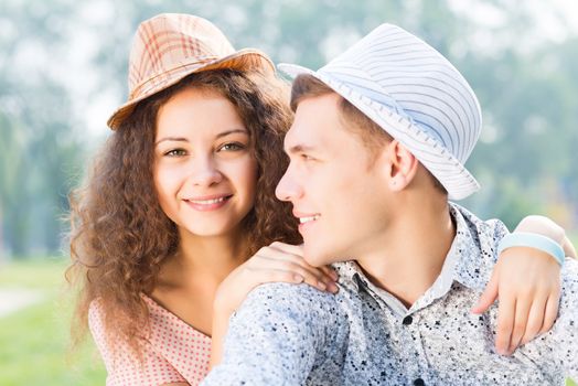 romantic couple lying on the grass in the summer park, spending time with loved ones