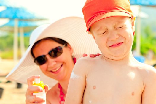 Mom puts on the baby's skin lotion for sun protection