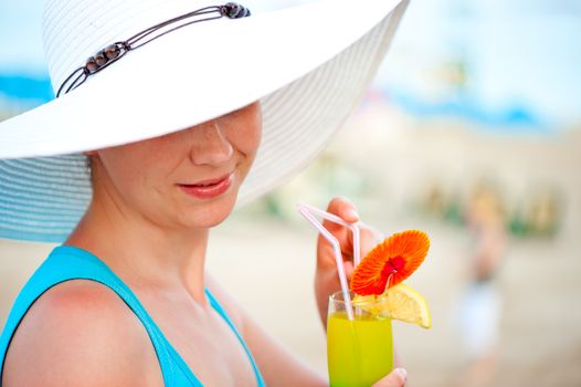 young woman in white hat with a glass of alcoholic cocktail