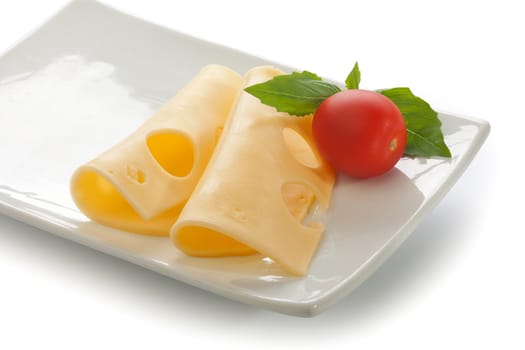 Slices of cheese with basil and tomato on the plate