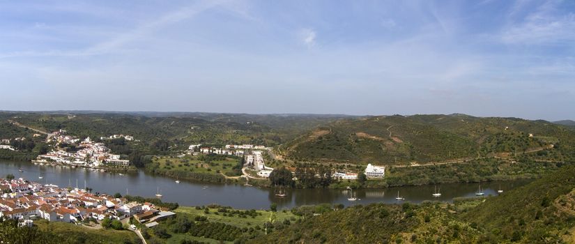 Panoramic view of spanish Sanlucar and Portuguese Alcoutim towns divided by the Guadiana river.