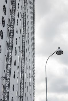 Modern building with round windows and street lamp.