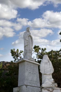 statue of the virgin mary against a blue sky