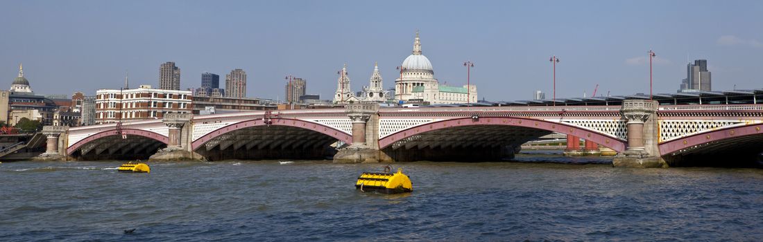 Blackfriars Bridge in London.  The dome and towers of St. Paul's Cathedral are in the distance.