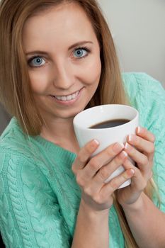 smiling young woman drinking coffee in the morning