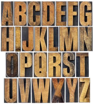 complete English alphabet - a collage of 26 isolated vintage wood letterpress printing blocks, scratched and stained by ink