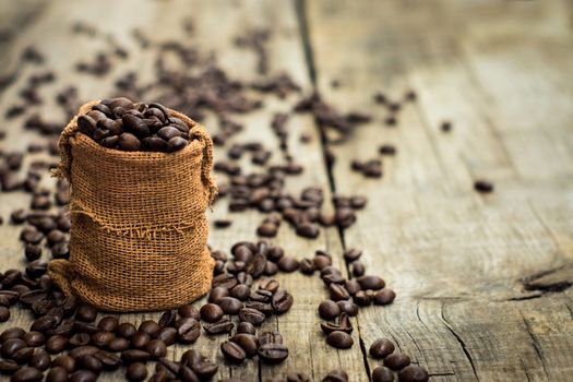 A bag of coffee beans on wood textured background