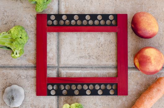 empty picture frame on ceramics tiles with fruits and vegetables