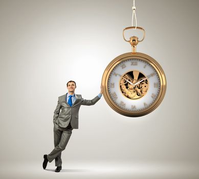 Image of young businessman and pocket watch. Time concept