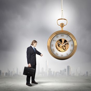 Image of young businessman and pocket watch. Time concept