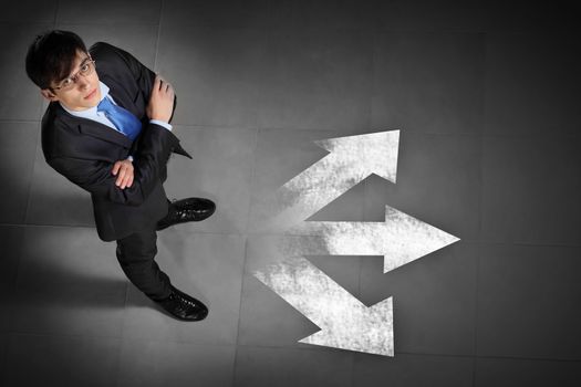 Top view of businessman standing against directions background