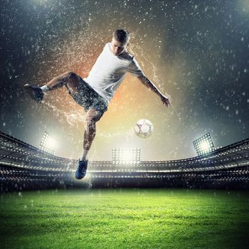 football player in white shirt striking the at the stadium under the rain