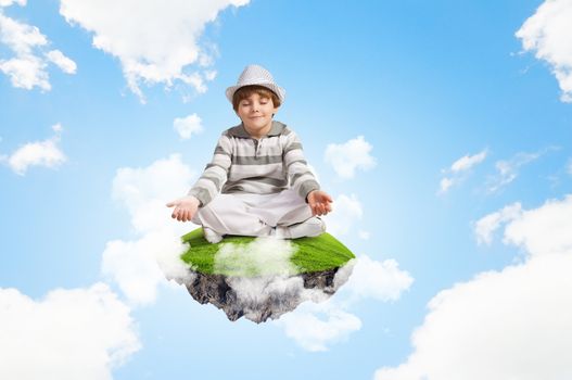 Image of little boy sitting on cloud and meditating