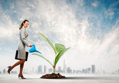 Image of businesswoman watering tree with pot. Ecology concept