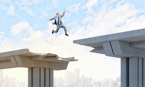 Businessman jumping over a gap in the bridge as a symbol of bridge