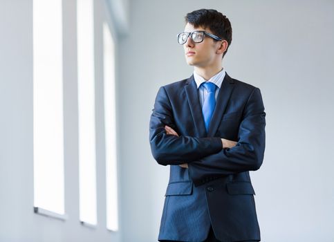 Image of handsome businessman in glasses with arms crossed on chest