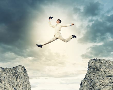 Image of young businessman jumping over gap