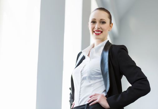 Image of young attractive businesswoman in business suit smiling