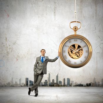 Image of young businessman and pocket watch. Time concept