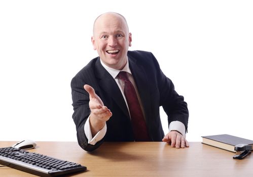 businessman leaning over desk offering a handshake isolated on white