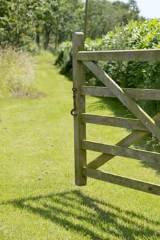 Open gate to grass pathway on a summers day.