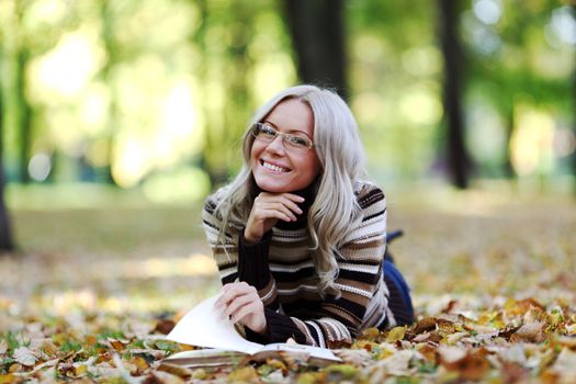 woman read the book in autumn park