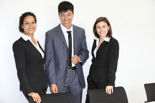 Confident successful young multiethnic business team standing together in the office smiling at the camera