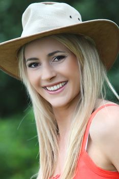Vertical close-up portrait of a beautiful young Caucasian woman wearing a fancy hat and looking at camera