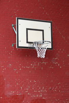 Close-up of a basket hoop fixed on a red brick wall, shot from low angle