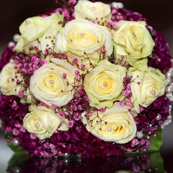 Unusual bridal bouquet with fresh yellow roses interspersed with tint dainty pink flowers, close up view