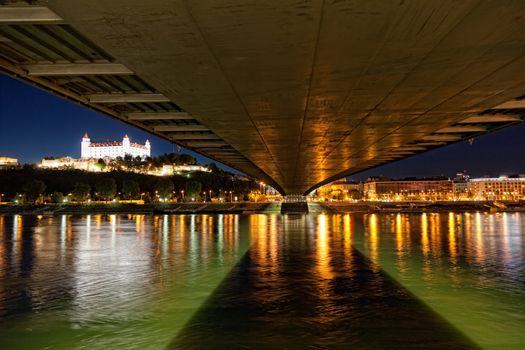 View of a medieval castle in Bratislava from under the bridge through Danube