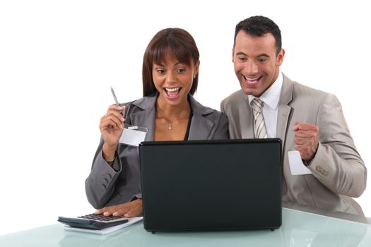 Cheerful business professionals watching a video on their laptop