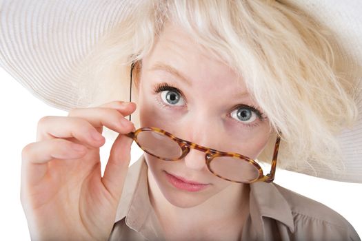Skeptical blond female looking over eyeglasses on isolated background