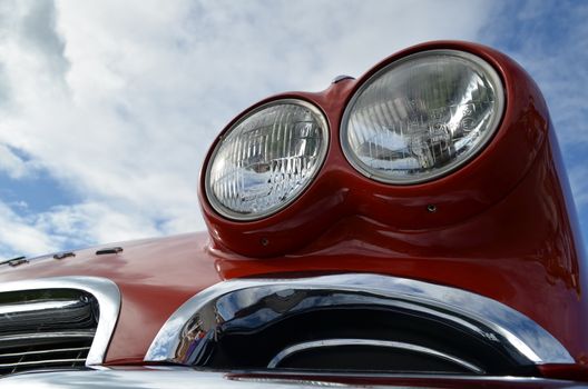 Fully restored American classic car showing bright chrome and paintwork and twin headlamps.
