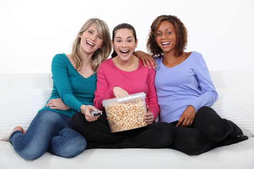 Friends laughing and eating popcorn