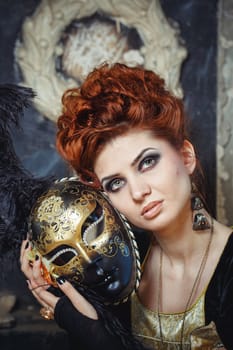 Close-up portrait of red-haired woman holding a mask shot outdoors