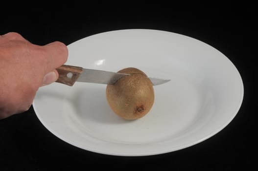 Cutting a Green and Brown Kiwi in Two Parts