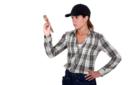 Determined woman holding up a paintbrush