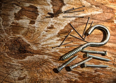 still-life of nails and screws on an aged wood plank