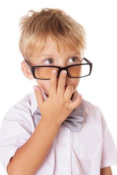 Serious boy adjusting glasses on nose over white