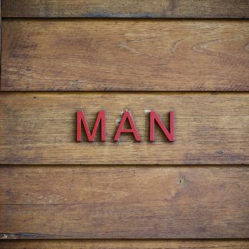 man toilet symbolic on wood background texture