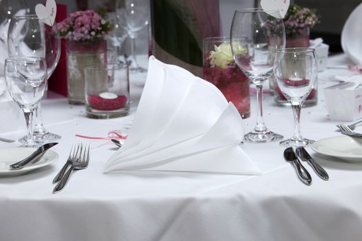 Formal place setting with luxury linen folded in a decorative fan shape at a celebration or party at a catered event