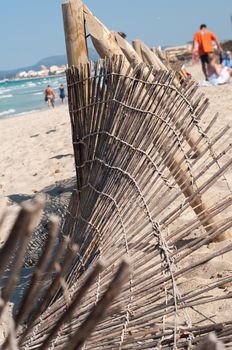 Shot of fence on the beach, blue sky and sand